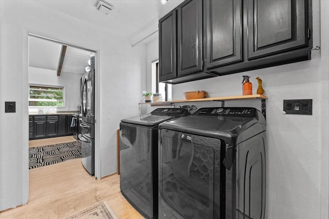 19697 Old Indian Trl, Redding, CA 96003 - laundry room with light wood-type flooring, washing machine and dryer, and cabinet space