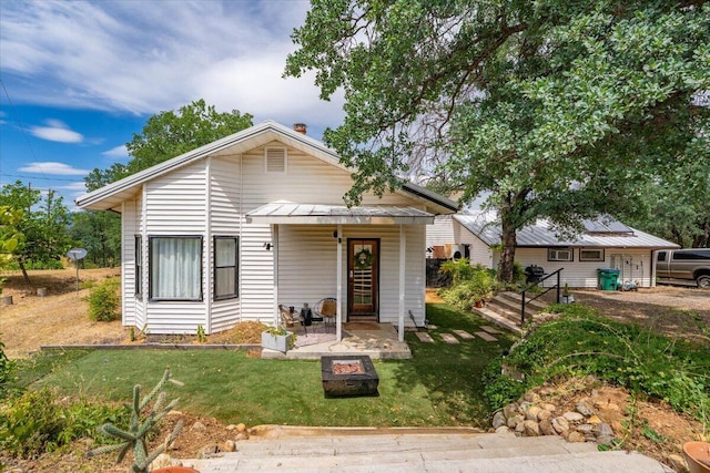 19697 Old Indian Trl, Redding, CA 96003 - bungalow-style house with an outdoor fire pit, a front yard, a patio area, and metal roof