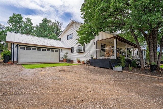 19697 Old Indian Trl, Redding, CA 96003 - view of front facade featuring driveway, an attached garage, a porch, and metal roof