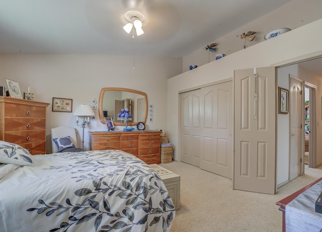 bedroom with light colored carpet, a closet, lofted ceiling, and ceiling fan