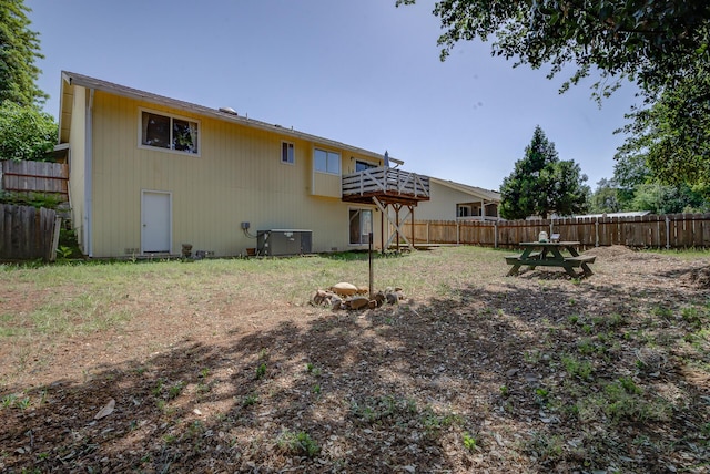 back of house featuring a fenced backyard, a deck, and cooling unit