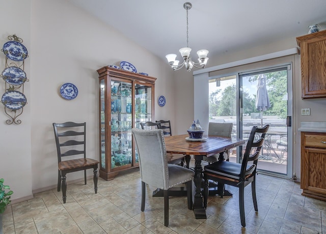 dining room with a chandelier, stone finish flooring, lofted ceiling, and baseboards