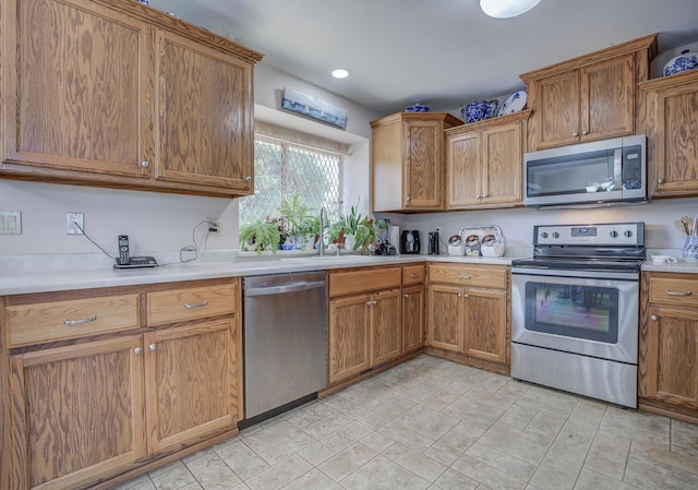 kitchen featuring stainless steel appliances, light countertops, and brown cabinets