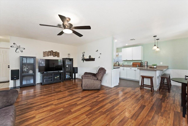 2682 Marvin Trl, Redding, CA 96001 - living area featuring dark wood-style floors, a ceiling fan, and a wainscoted wall