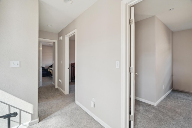 corridor with carpet floors and baseboards