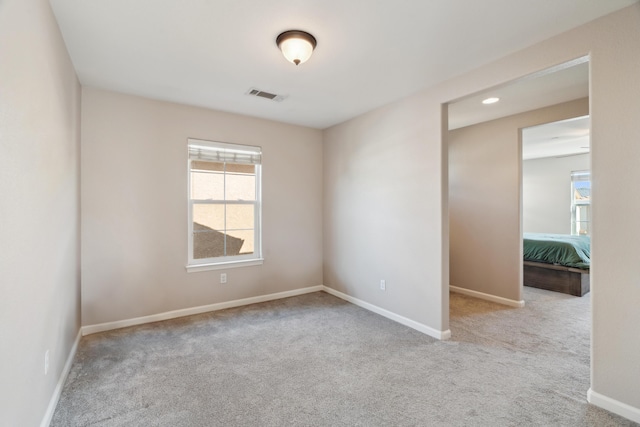 unfurnished room featuring carpet floors, plenty of natural light, and baseboards