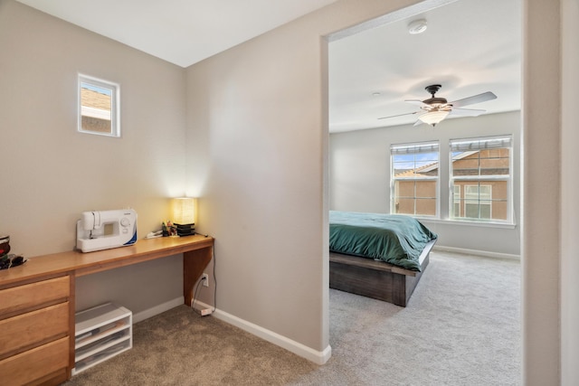 carpeted bedroom with baseboards, multiple windows, and an office area