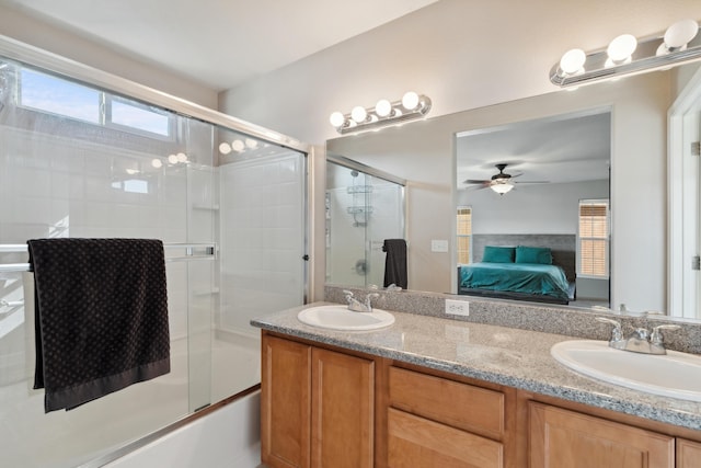 full bathroom with ensuite bathroom, double vanity, a ceiling fan, and combined bath / shower with glass door