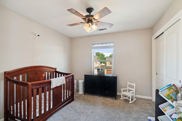 bedroom featuring carpet, a closet, ceiling fan, baseboards, and a nursery area