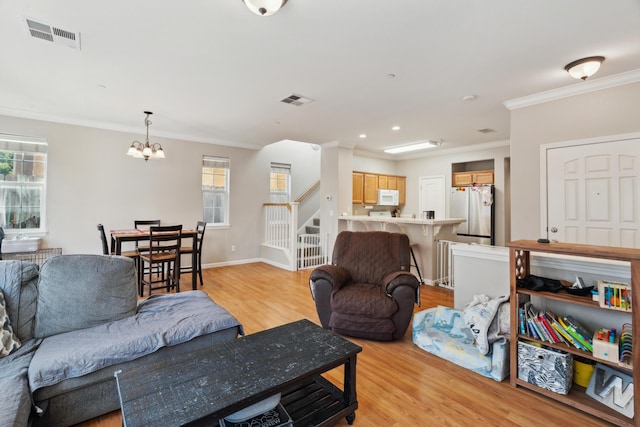 living room with stairway, light wood-style flooring, crown molding, a chandelier, and baseboards