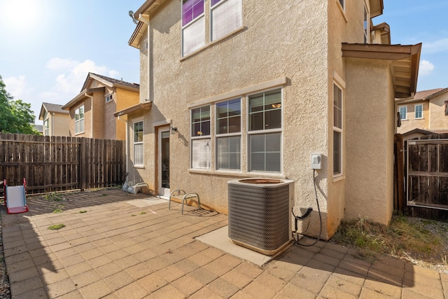 view of patio / terrace with central air condition unit and fence