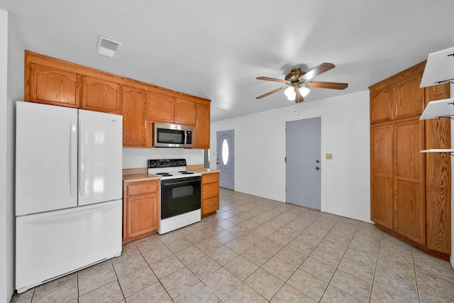 1945 Luning St, Red Bluff, CA 96080 - kitchen with freestanding refrigerator, electric range, stainless steel microwave, a ceiling fan, and light countertops