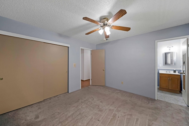 1945 Luning St, Red Bluff, CA 96080 - unfurnished bedroom with light carpet, a sink, connected bathroom, a closet, and a textured ceiling