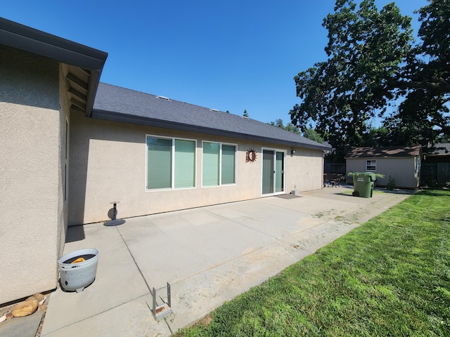 3621 Sacramento Dr, Redding, CA 96001 - rear view of house featuring stucco siding, a patio, a yard, a shed, and roof with shingles