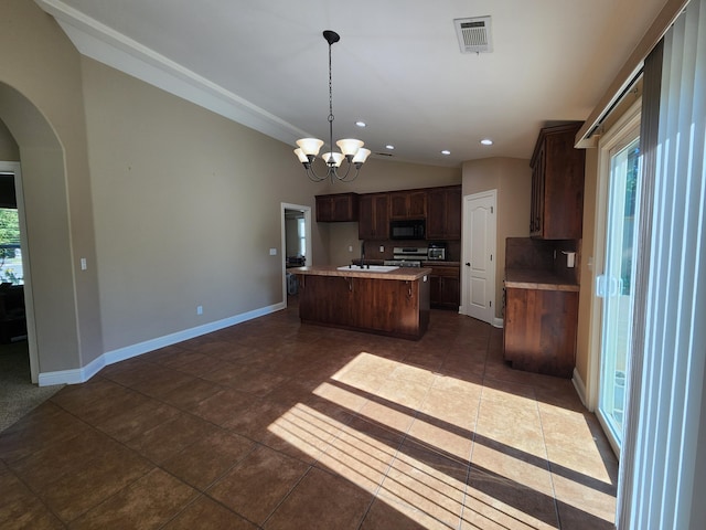 3621 Sacramento Dr, Redding, CA 96001 - kitchen featuring black microwave, lofted ceiling, tasteful backsplash, stainless steel range, and healthy amount of natural light