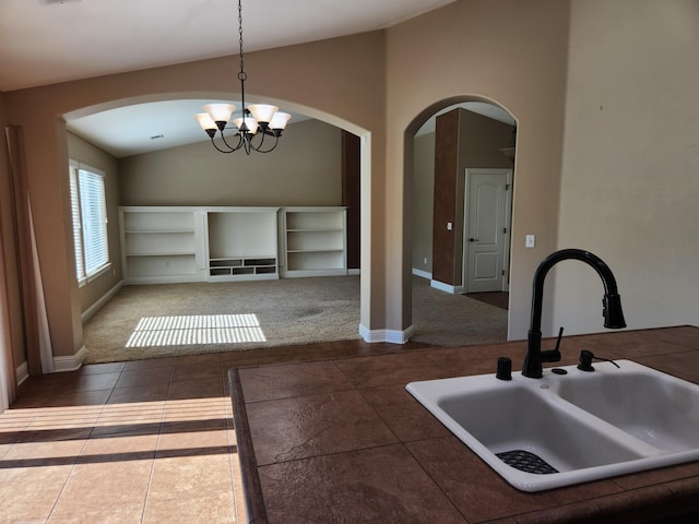 3621 Sacramento Dr, Redding, CA 96001 - kitchen with lofted ceiling, arched walkways, a chandelier, hanging light fixtures, and tile patterned flooring