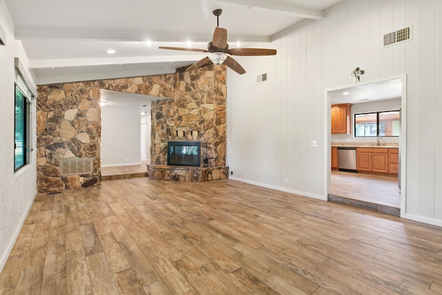 5165 Rancho Vista Way, Redding, CA 96002 - unfurnished living room with a stone fireplace, light wood-style flooring, a ceiling fan, and a sink