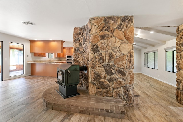 5165 Rancho Vista Way, Redding, CA 96002 - detailed view of a wood stove, built in microwave, wood finished floors, baseboards, and oven