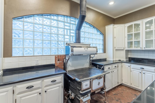 17917 Lakeshore Dr, Weed, CA 96094 - kitchen with decorative backsplash, brick flooring, dark countertops, white cabinetry, and crown molding