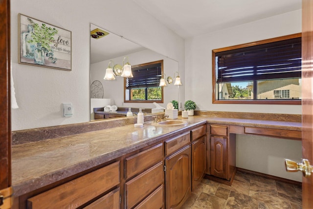 kitchen featuring a sink, stone finish floors, and brown cabinets