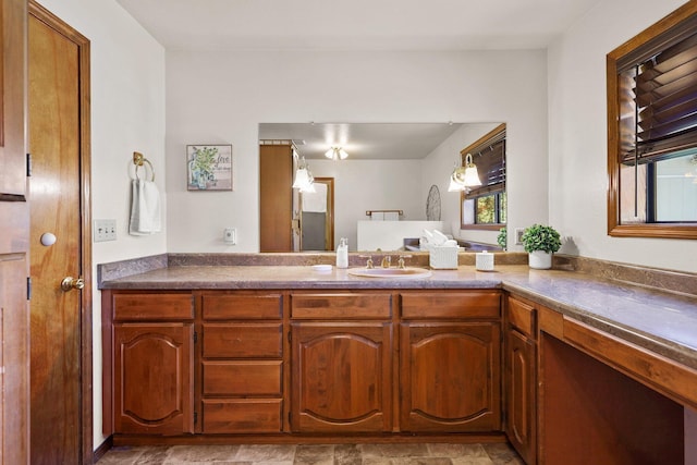 kitchen with a sink, brown cabinets, and dark countertops