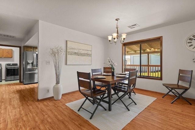 dining room with a chandelier, light wood-style floors, and baseboards