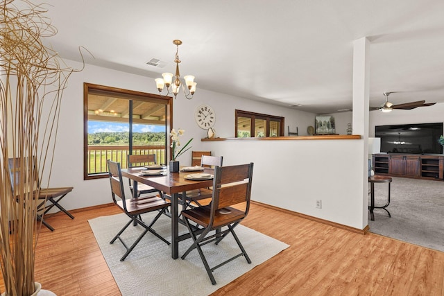 dining area with light wood-style floors, baseboards, a chandelier, and ceiling fan