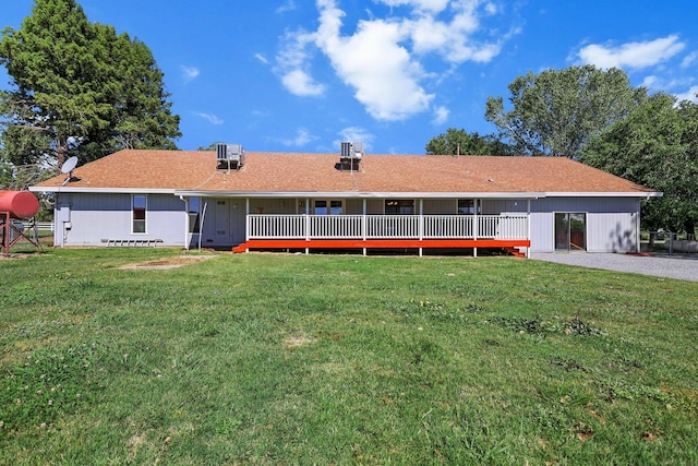 rear view of property featuring a lawn and central AC unit