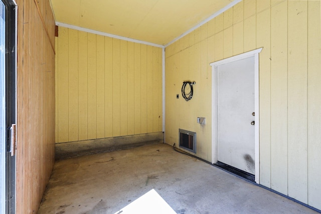empty room with unfinished concrete flooring and wood walls