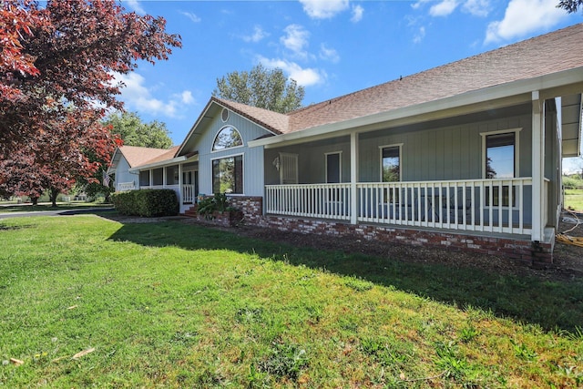 view of front of property featuring a shingled roof, a front lawn, and covered porch
