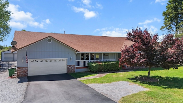 view of front of house featuring a porch, a front lawn, an attached garage, driveway, and a shingled roof