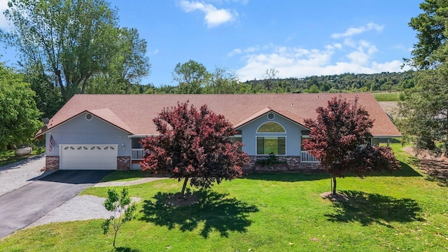 view of front facade featuring stone siding, asphalt driveway, an attached garage, and a front yard