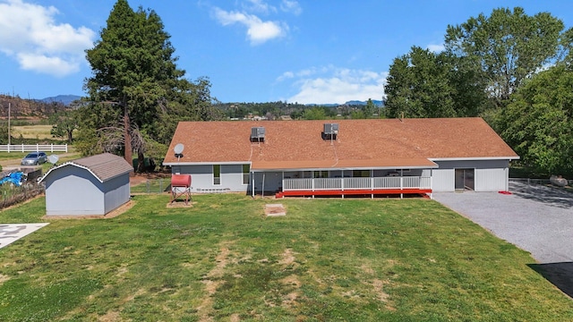 view of front of house featuring a front lawn, an outbuilding, a mountain view, and a storage unit