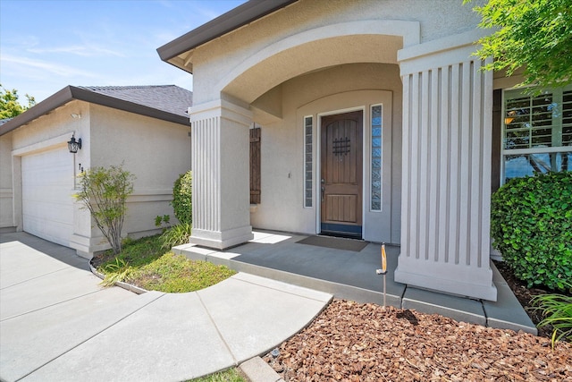 792 Bellagio, Redding, CA 96003 - doorway to property featuring an attached garage and stucco siding
