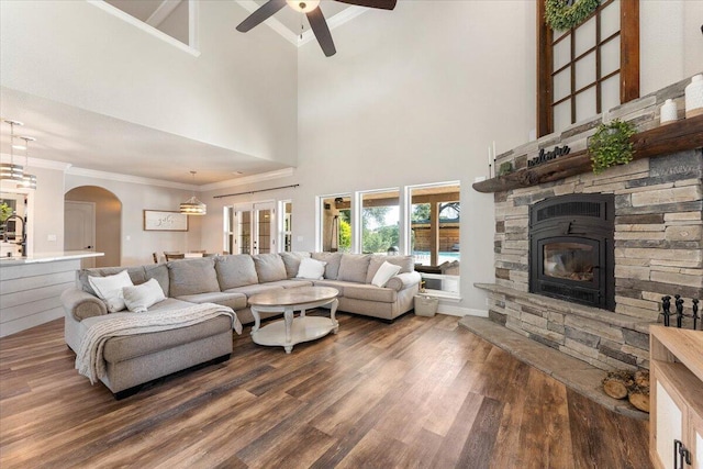20030 Clay Ct, Cottonwood, CA 96022 - living area featuring crown molding, a ceiling fan, dark wood-type flooring, a towering ceiling, and a stone fireplace