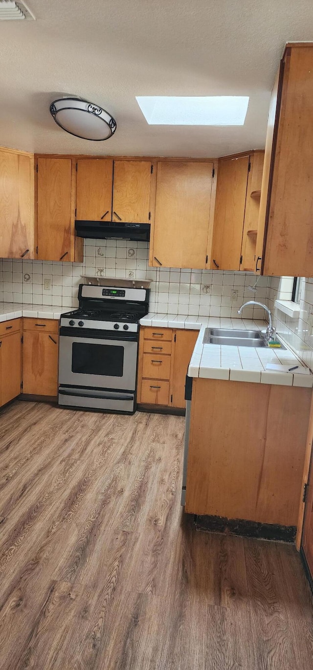 7670 Cedar Crest Rd, Shingletown, CA 96088 - kitchen with gas range, tile countertops, a sink, and wood finished floors