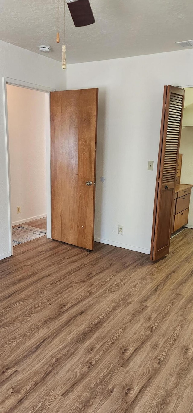 7670 Cedar Crest Rd, Shingletown, CA 96088 - unfurnished bedroom with wood finished floors, baseboards, ceiling fan, and a closet