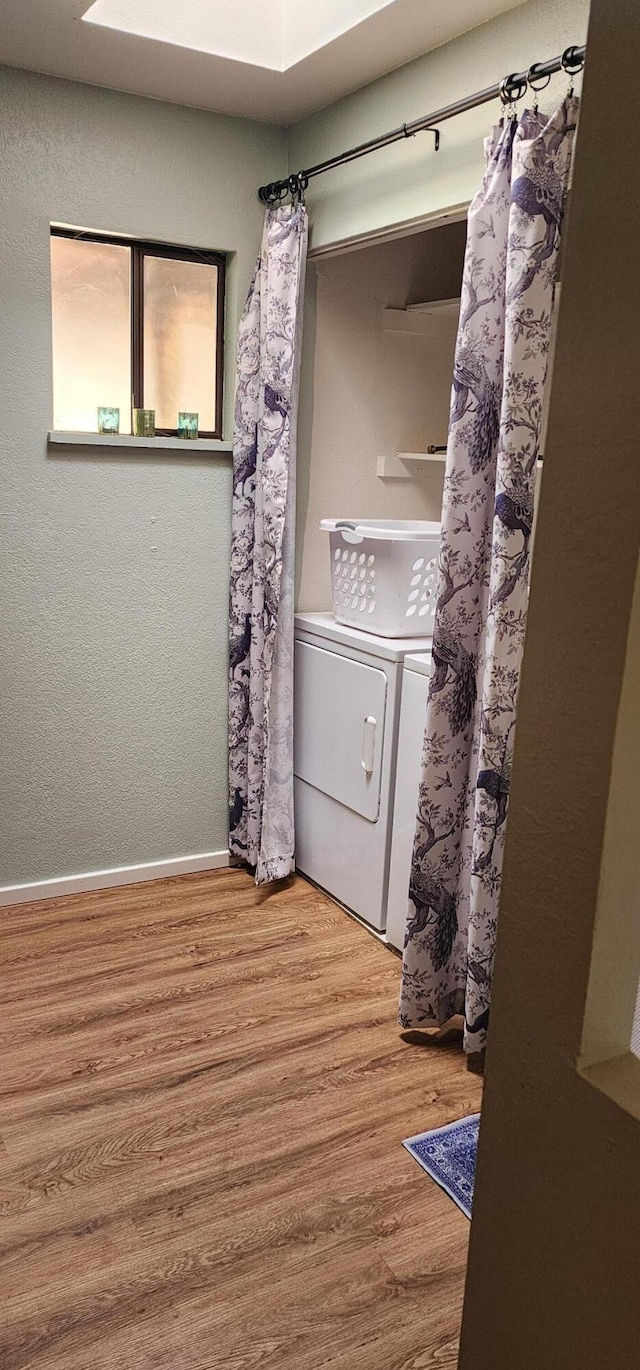 7670 Cedar Crest Rd, Shingletown, CA 96088 - laundry area featuring wood finished floors, washing machine and clothes dryer, and baseboards