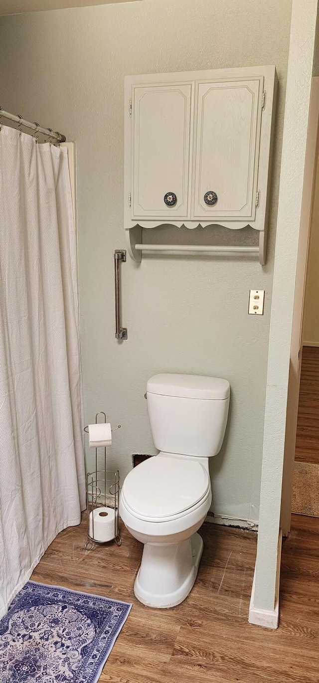 7670 Cedar Crest Rd, Shingletown, CA 96088 - bathroom with wood finished floors, toilet, a shower with curtain, and baseboards