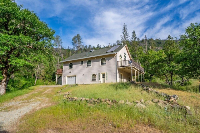 12876 E Fork Rd, French Gulch, CA 96033 - view of home's exterior with dirt driveway, a garage, a wooden deck, and a forest view