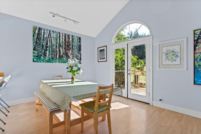 12876 E Fork Rd, French Gulch, CA 96033 - dining room with rail lighting, light wood-style flooring, baseboards, french doors, and high vaulted ceiling