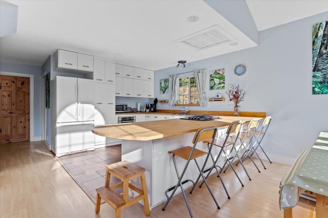 12876 E Fork Rd, French Gulch, CA 96033 - kitchen featuring appliances with stainless steel finishes, a breakfast bar, light wood-style floors, and butcher block counters
