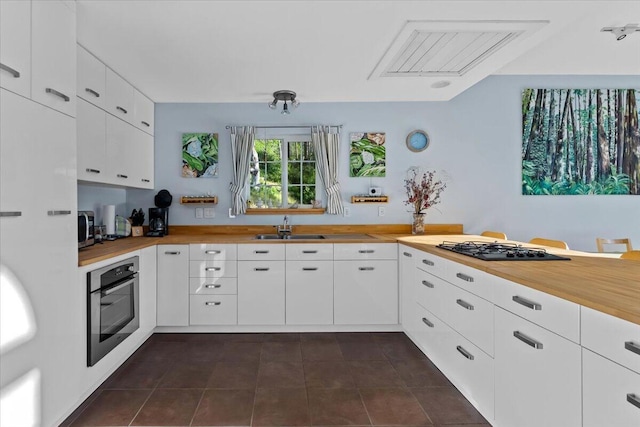 12876 E Fork Rd, French Gulch, CA 96033 - kitchen featuring stainless steel appliances, wooden counters, a sink, dark tile patterned flooring, and white cabinets