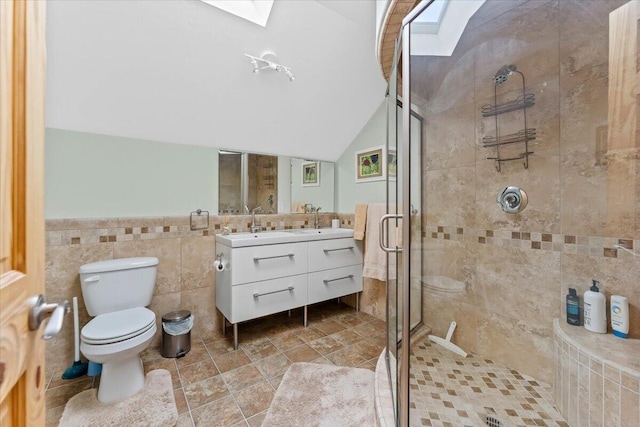 12876 E Fork Rd, French Gulch, CA 96033 - bathroom featuring vaulted ceiling, a stall shower, tile walls, toilet, and a skylight