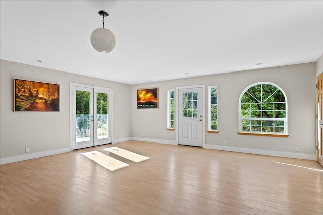 12876 E Fork Rd, French Gulch, CA 96033 - unfurnished living room featuring light wood-style flooring, french doors, plenty of natural light, and baseboards