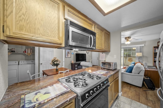 200 Ridgetop Dr # 26, Redding, CA 96003 - kitchen featuring black gas stove, stainless steel microwave, independent washer and dryer, a ceiling fan, and open floor plan