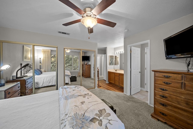 200 Ridgetop Dr # 26, Redding, CA 96003 - bedroom featuring two closets, light carpet, a ceiling fan, ensuite bath, and baseboards