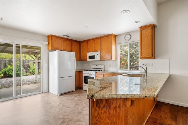 117 Yolla Bolly Trl, Redding, CA 96003 - kitchen featuring white appliances, a sink, a peninsula, and decorative backsplash