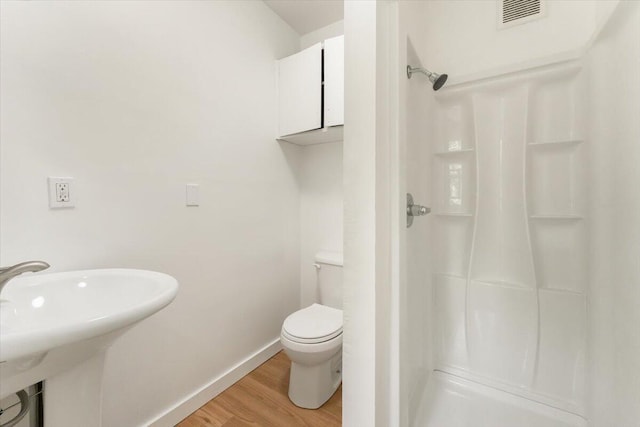 5985 Dunsmuir Ave, Dunsmuir, CA 96025 - bathroom featuring wood finished floors, a stall shower, baseboards, toilet, and a sink