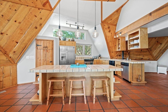 19028 Rocky Trl, Lakehead, CA 96051 - kitchen with stainless steel appliances, tile countertops, a breakfast bar, dark tile patterned floors, and a towering ceiling